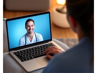 A person engaging in a video call with a healthcare professional on a laptop, demonstrating accessible telehealth services from home.